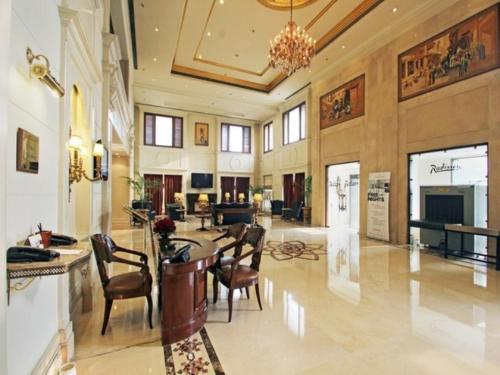 a lobby with a table and chairs in a building at Radisson Hotel Jalandhar in Jalandhar