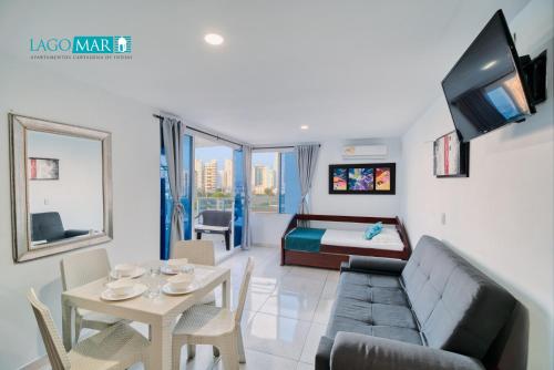 ein Wohnzimmer mit einem Sofa, einem Tisch und einem Bett in der Unterkunft Lagos y Mar Apartamentos Cartagena in Cartagena de Indias