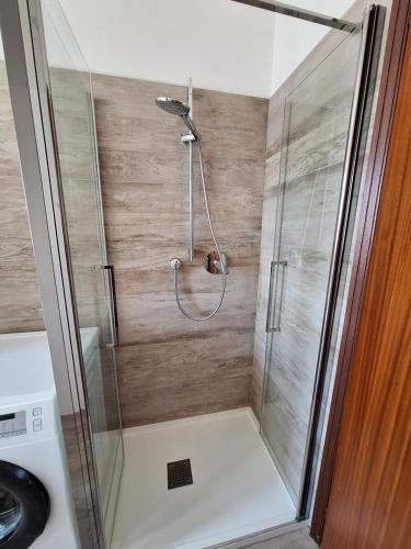 a shower with a glass door in a bathroom at King 35 in Bologna
