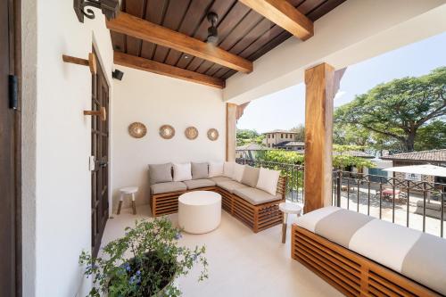 Un patio con un sofá y una mesa en un balcón. en Beach, Oceanfront 2BR, 2BA Condo in Las Catalinas - Plaza Mercado 12, en Playa Danta