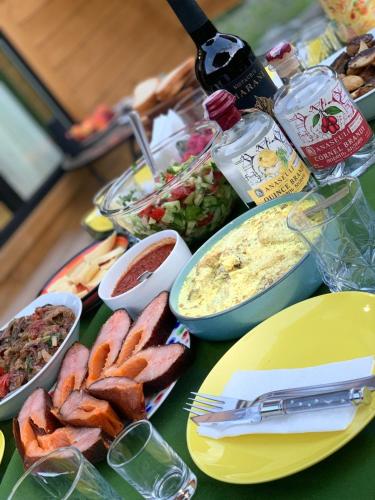 a table topped with different types of food on a table at Wooden House Nica in Mestia