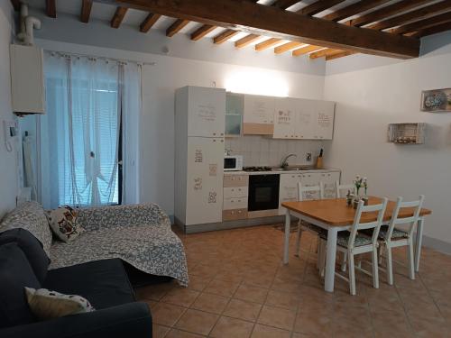a living room with a table and a kitchen at Shabby House in Podere Modello