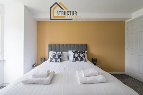 a bedroom with a large white bed with two pillows at Modern 3 Bedroom Apt near City Centre Parking included in Belfast