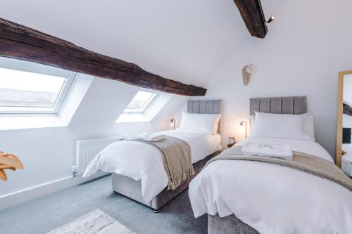 Number 21: A Breathtaking Chester Cottage with Parking في Mollington: سريرين في غرفة بجدران بيضاء ونافذة