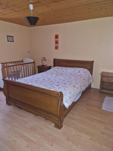 a bedroom with a wooden bed and a wooden floor at Week-end séjour à la campagne in Cornimont