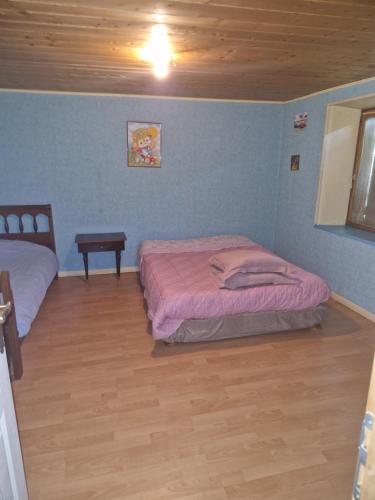 a bedroom with two beds and a wooden floor at Week-end séjour à la campagne in Cornimont