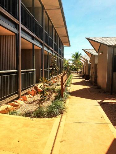 a sidewalk next to a building with a fence at Spinifex Hotel in Derby