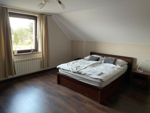 a bedroom with a bed with white sheets and a window at MiiG Residence Jacuzzi & Sauna Zator Oświęcim in Oświęcim