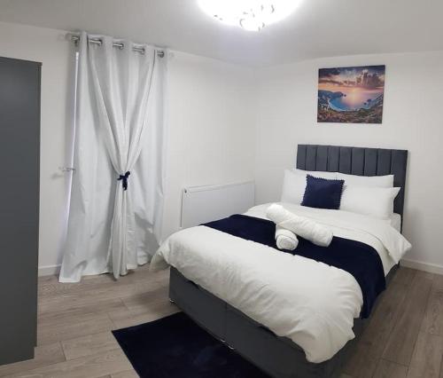 a bedroom with a large bed with blue and white pillows at Holiday Let - Entire modern home in Medway in Gillingham