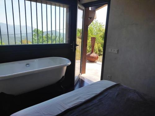 eine Badewanne in einem Zimmer mit Fenster in der Unterkunft Masía La Garrotxa in Olot