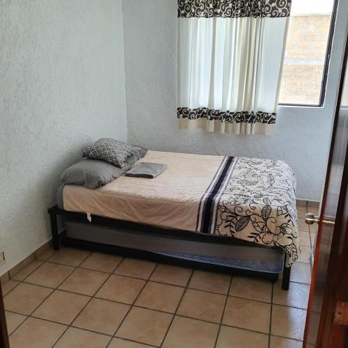 a small bed in a room with a window at Warriors Burgos in Temixco