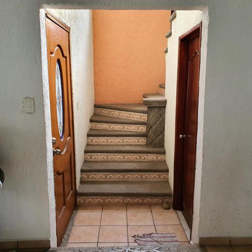 a hallway with a staircase leading to a door at Warriors Burgos in Temixco
