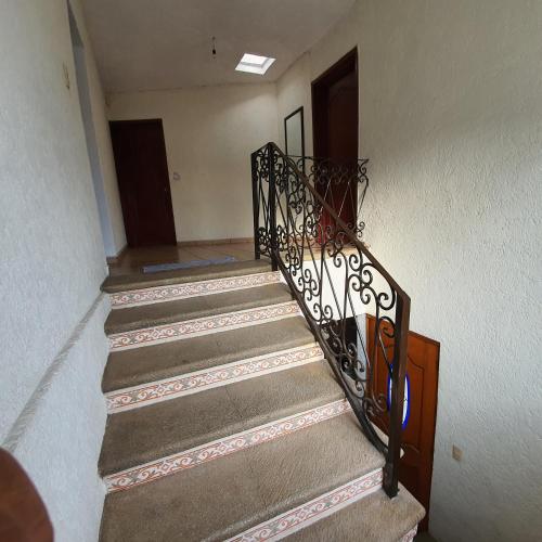 a staircase with a wrought iron railing in a house at Warriors Burgos in Temixco
