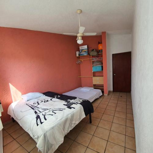 a bedroom with a bed and a red wall at Warriors Burgos in Temixco