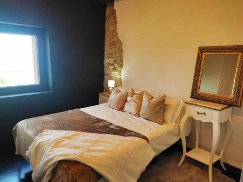 a bedroom with a bed with a mirror and a table at Masía La Garrotxa in Olot