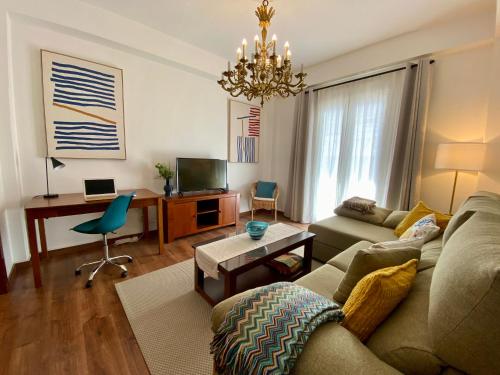 Una sala de estar con un sofá y un escritorio. en VISTA PLAZA - Exceptional Location, en Los Llanos de Aridane