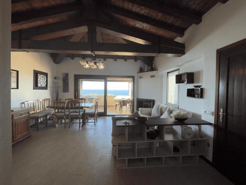 un soggiorno con cucina e una sala da pranzo di PUNTA EST QUADRILOCALE TERRAZZA FAVOLOSA VISTA MARE a Capo Coda Cavallo