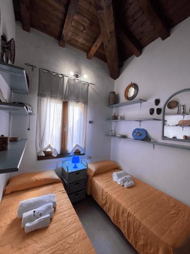 a bedroom with two beds and a mirror at PUNTA EST QUADRILOCALE TERRAZZA FAVOLOSA VISTA MARE in Capo Coda Cavallo