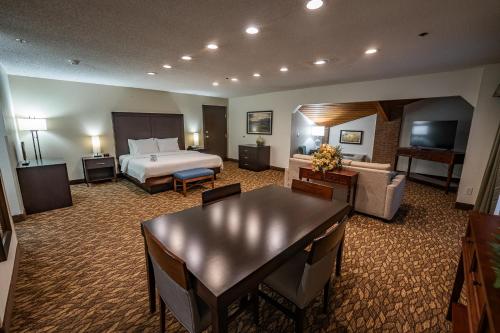 a large hotel room with a bed and a table at Christopher Inn and Suites in Chillicothe