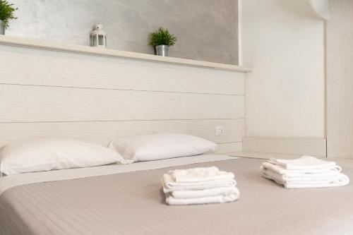 a bed with white towels on top of it at Hotel Hawaii Bed and Coffee in Riccione