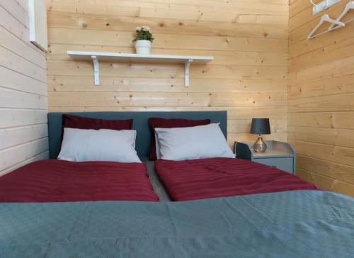 1 Schlafzimmer mit 2 Betten und roter Bettwäsche in der Unterkunft Gästehaus Lilla-Viken in Stöde
