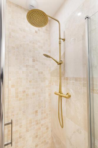une douche avec pommeau de douche dans une salle de bain dans l'établissement Montmartre 2 Pièces, à Paris