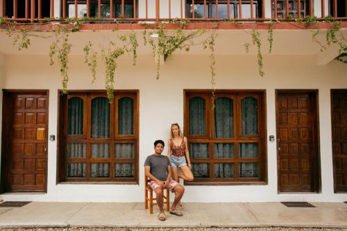 Ein Mann und eine Frau sitzen vor einem Gebäude in der Unterkunft Casa Triz in Puerto Escondido