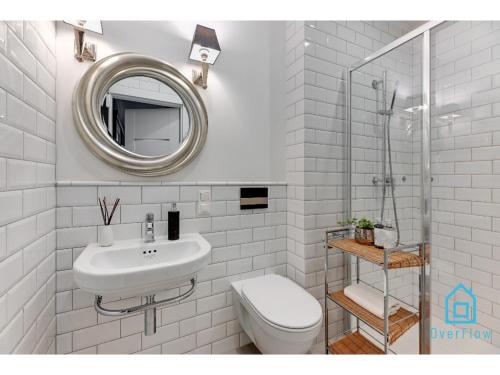 a bathroom with a sink and a toilet and a mirror at Libertas Premium Apartment at Old Town Gdansk in Gdańsk