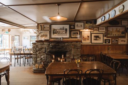 a restaurant with a stone fireplace and tables and chairs at Cardrona Hotel in Cardrona