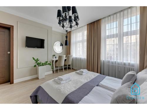 a bedroom with a bed and a table and a television at Libertas Premium Apartment at Old Town Gdansk in Gdańsk