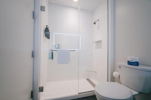 a white bathroom with a toilet and a shower at The Charles F. Knight Center in University City