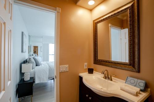 uma casa de banho com um lavatório, um espelho e uma cama em Le Cartier Apartments Sunny Isles em Sunny Isles Beach