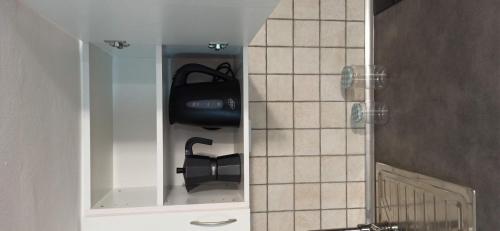 baño con armario blanco con silla negra en Amplio apartamento recién reformado en Tejina