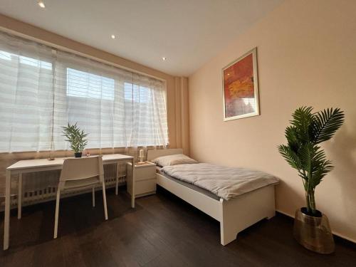 a bedroom with a bed and a table and a window at Eterna Comfort Living in Essen