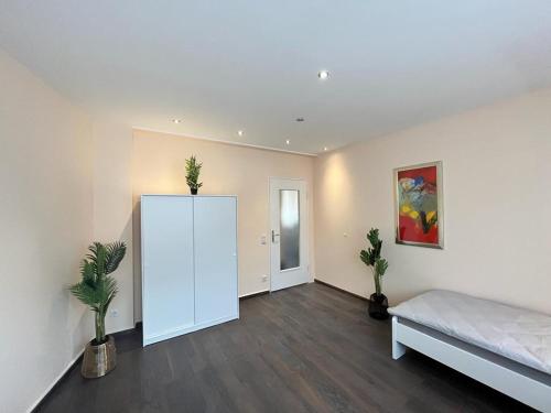 エッセンにあるEterna Comfort Livingの白い壁の広い客室で、ベッド1台が備わります。