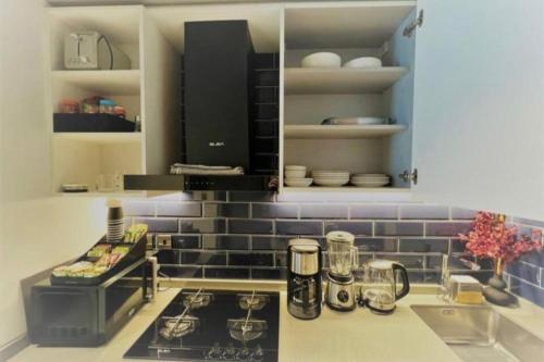 um modelo de cozinha com fogão e electrodomésticos em Modern Apartment close to Burj Khalifa em Al Faq‘
