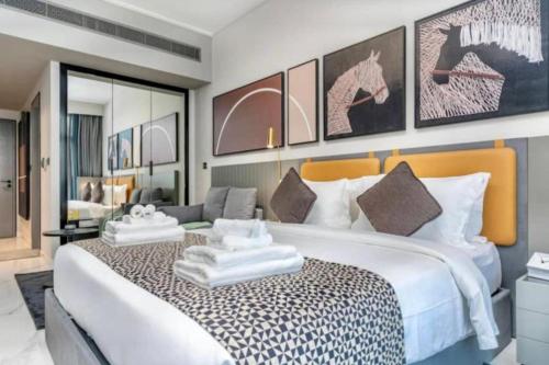 a bedroom with a large bed with two towels on it at Modern Apartment close to Burj Khalifa in Al Faq‘