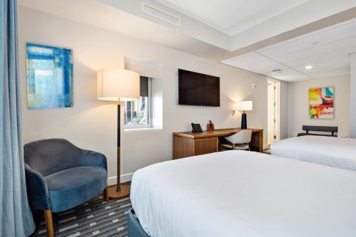 um quarto de hotel com uma cama e uma cadeira em The Charles F. Knight Center em University City