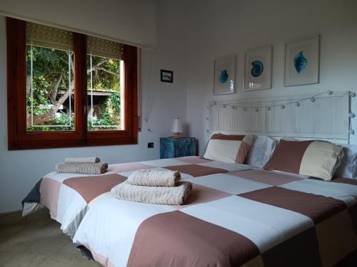 a bedroom with two beds with pillows on them at Casa Sa Posidonia -POSIDONIA SURF & STAY- in Ciutadella