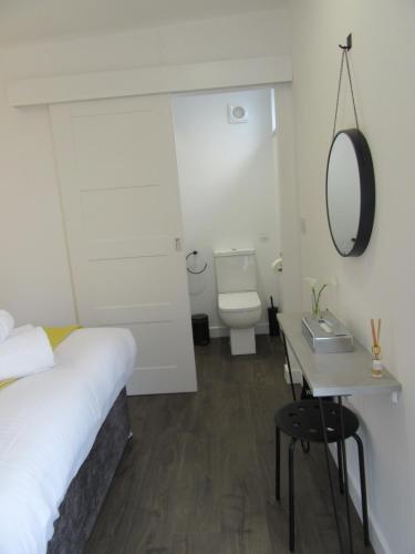 sypialnia z łóżkiem, toaletą i lustrem w obiekcie Portree But & Ben w mieście Portree