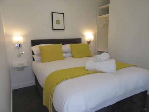 a bedroom with a large white bed with yellow pillows at Portree But & Ben in Portree