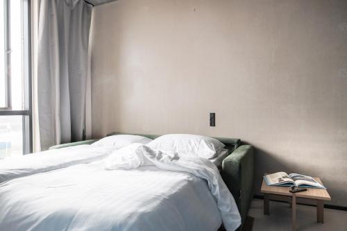 a bedroom with two beds with white sheets and a table at Daniel&Jacob's urban studios and boutique apartments in Aarhus