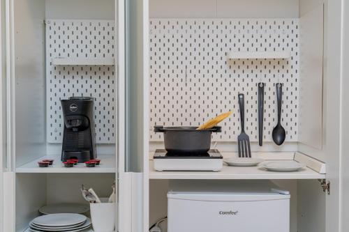 una cocina con un armario con algunos utensilios. en Residenze Asproni Serviced Apartments en Cagliari