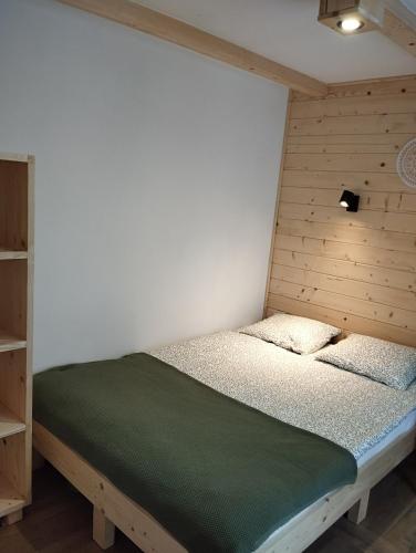 a bedroom with a bed with a wooden headboard at Ajurweda na Jurze Agroturystyka in Choroń