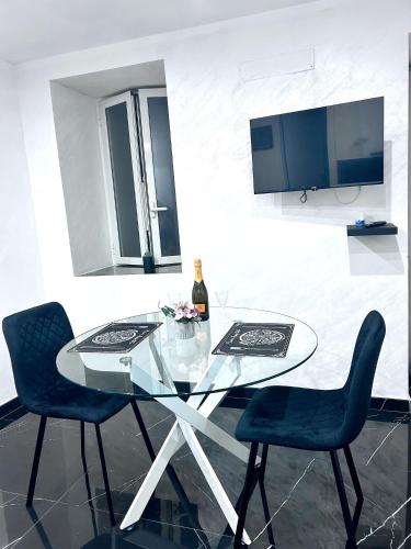 ein Glastisch mit zwei Stühlen und einer Flasche Wein in der Unterkunft Sweet Dreams luxury 3 in Neapel
