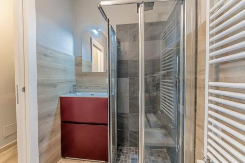 een glazen douche in een badkamer met een rode kast bij Casa Balbi al Mare, giardino e posto auto privato in Albisola Superiore