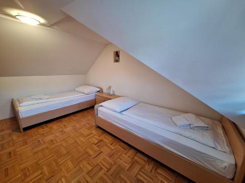 two beds in a small room with a staircase at Župnijski apartmaji in Dolenjske Toplice