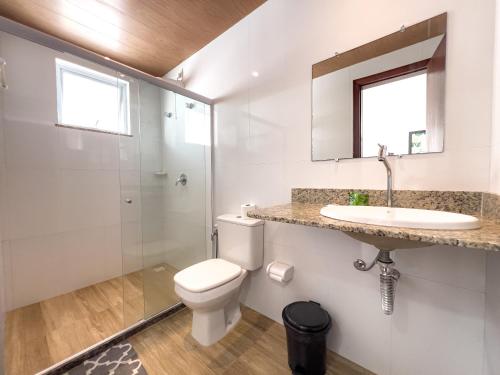 a white bathroom with a toilet and a sink at Pousada Linda flor in Morro de São Paulo