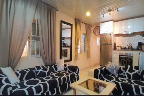 ein Wohnzimmer mit 2 Sofas und einer Küche in der Unterkunft Bienvenue in Accra