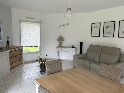 un salon avec un canapé et une table dans l'établissement Chambres d'hôtes chez Nanou la Puyfolaise - 1 ou 2 chambres, à Saint-Laurent-sur-Sèvre